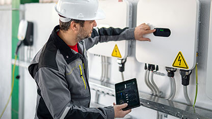 Engineer using a digital tablet to examine electric smart grid system